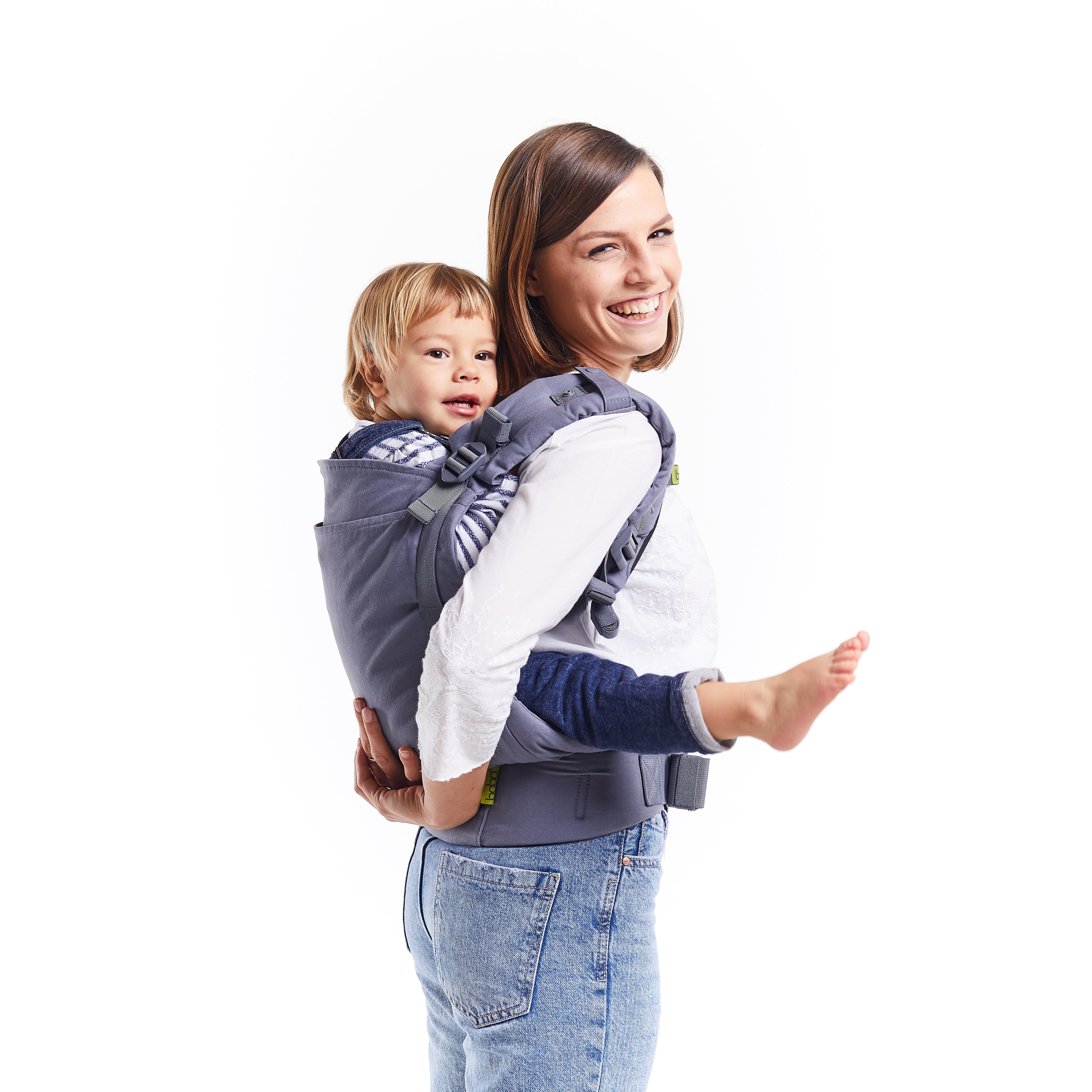 A happy young mom with her toddler girl in a back carry ergonomic position in the gray boba x