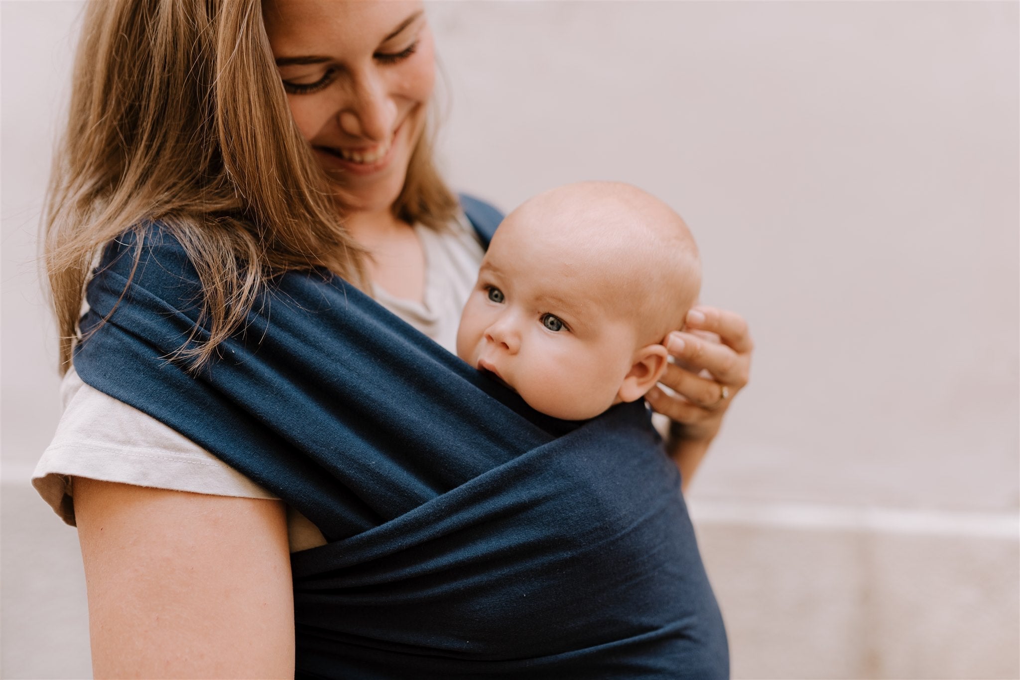 Cute mother and baby duo are enjoying their babywearing experience with the navy boba classic wrap.